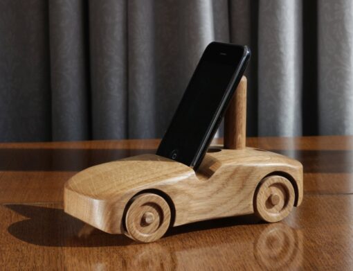 Oak wood phone stand in the shape of a car - 3rd angle with a small phone in portrait