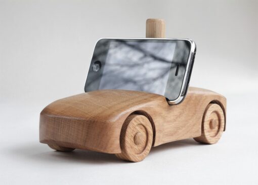 Oak wood phone stand in the shape of a car f- front and side visible, black phone